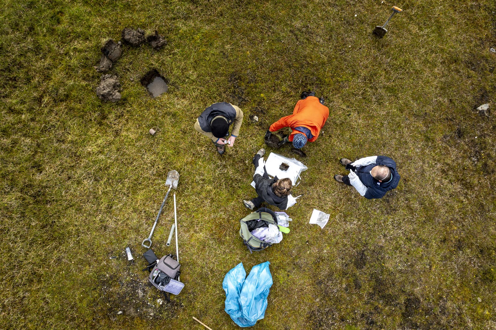 Photo from above of four researchers and their gear around a sampling site.